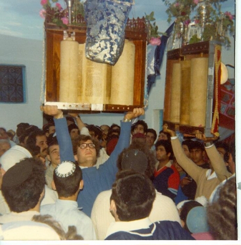 Jeune homme élevant la Torah lors de sa nouvelle installation à Djerba